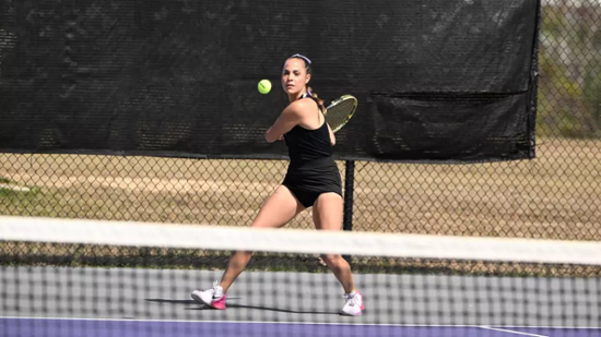 Knights women's tennis player hits the ball during a match. 